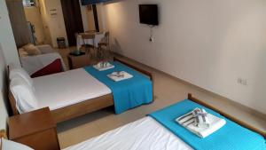 a small room with two beds and a table with a tray at Celia`s Studio in Nea Peramos