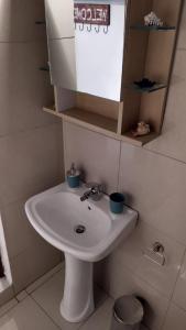 a bathroom with a white sink and a mirror at Celia`s Studio in Nea Peramos