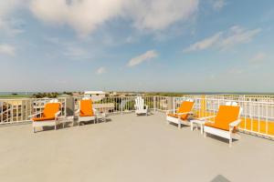 a balcony with orange chairs and a view of the ocean at Laguna Suites in San Pedro