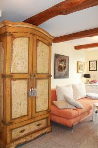 a bedroom with an orange bed with a wooden cabinet at FeWo Direkt Am See - Malchow in Malchow