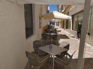 eine Reihe von Tischen und Stühlen mit Sonnenschirmen auf einer Straße in der Unterkunft Hotel Mesón El Número Uno in Antequera