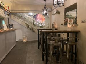 a bar with stools in a room with stairs at Uplands Inn Cartmel in Cartmel