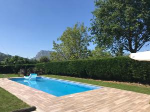 a swimming pool in a yard with a wooden deck at Agroturismo Gure Naia in Carranza