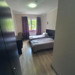 sypialnia z 2 łóżkami i oknem w obiekcie JURAJSKI OLSZTYN w mieście Olsztyn