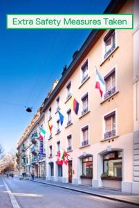 un grande edificio con bandiere a lato di Hotel AlaGare a Losanna