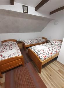 a room with three beds in a room at Pensiunea Răzvan in Gura Râului