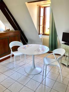una mesa blanca y 2 sillas en una habitación en Studio Le Gachet en Pouligny-Notre-Dame