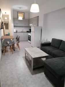 a living room with a couch and a table and a kitchen at FantaSea Apartments in Haraki