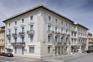a large white building on the corner of a street at Palace Hotel in Viareggio
