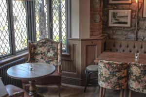 a dining room with a table and chairs and windows at The Pooley Bridge Inn in Pooley Bridge