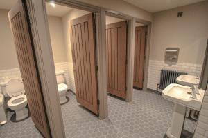 a bathroom with three toilets and two sinks at The Pooley Bridge Inn in Pooley Bridge