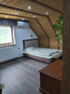 a bedroom with a bed in a wooden house at Kovácsszénája Vendégház in Kovácsszénája