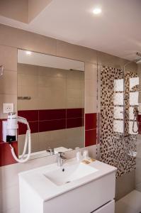 La salle de bains est pourvue d'un lavabo et d'un miroir. dans l'établissement Hôtel du Musée, à Arles