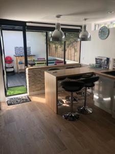 a kitchen with a counter and stools in a room at Maison bord mer in Labenne