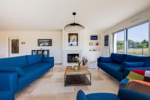 - un salon avec des canapés bleus et une table dans l'établissement TI LAOUEN - 300 m de la plage, à Sarzeau