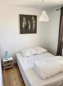 sypialnia z 2 łóżkami i zdjęciem piór w obiekcie Cabourg Proche Thalasso w mieście Cabourg