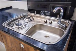 a stainless steel kitchen sink with a stove at Jacht motorowy Balt Tytan 1018 Fly in Wilkasy