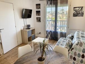 una sala de estar con un sofá y una mesa en Cabourg Proche Thalasso, en Cabourg