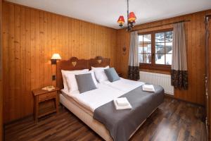 - une chambre avec un grand lit et une fenêtre dans l'établissement Petit Paradis, à Crans-Montana