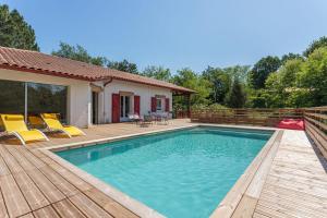 a swimming pool with chairs and a house at LANDAGAINA Villa with heated pool and garden Guethary close to Biarritz in Guéthary