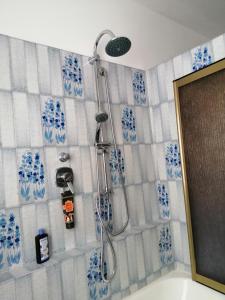 y baño con ducha y azulejos azules y blancos. en Le Viole Bianche, en Albiano dʼIvrea