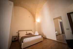 una camera con letto in una stanza con arco di La Dimora del Principe a Grottaglie