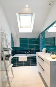 a bathroom with green tiles and a skylight at Chez Lilette in La Baule