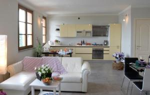 a living room with a white couch and a kitchen at Casa Cardinali in Pienza