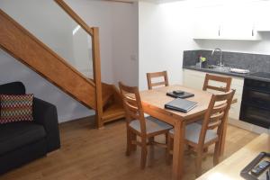 uma cozinha e sala de jantar com uma mesa de madeira e cadeiras em Malvern Stables em Great Malvern