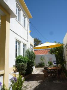 a patio with a table and an umbrella at Casa Londres in Estoril