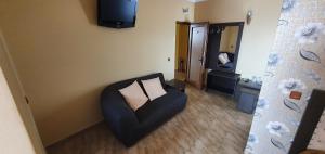 a living room with a chair and a television at LA CANAPELE ROCK in Vama Veche