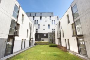 an alley between two buildings with grass in the middle at Neoresid - Résidence Lille-Lambret in Lille