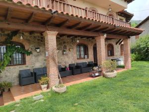 an outdoor patio with black furniture and a brick building at Casa Rural Aguas del Venero in Losar de la Vera