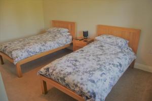 1 dormitorio con 2 camas y mesita de noche con lámpara en Malvern Stables en Great Malvern