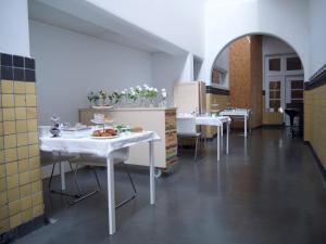 une salle à manger avec des tables et des chaises blanches dans un bâtiment dans l'établissement B&B De Kloostertuin, à Middelbourg