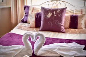 two swans laying on top of a bed at Witchingham B&B in Holyhead