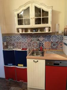 a kitchen with a sink and red and blue tiles at Mieszkanie Przy Plaży in Sopot