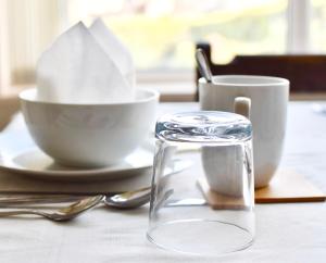 a table with a bowl and cups on a table at Witchingham B&B in Holyhead