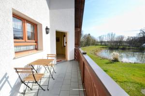 a balcony with tables and chairs and a view of a river at W-Apartments - Spacious Parking, EV-Station, Washer & Private Garden in Offenburg