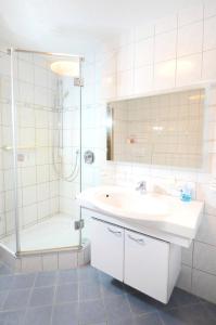 a white bathroom with a sink and a shower at Apartment Strasbourg - Europapark / Wallaston in Offenburg