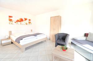a bedroom with a bed and a chair at Apartment Strasbourg - Europapark / Wallaston in Offenburg
