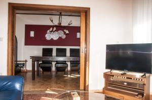 a dining room with a table and a television at Ferienhaus an der Mosel in Senhals