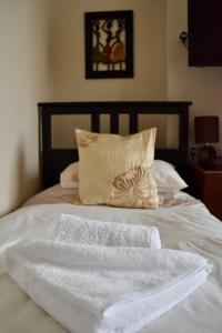 a bed with white towels on it with a pillow at Witchingham B&B in Holyhead