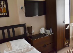 a bedroom with a bed and a flat screen tv at Witchingham B&B in Holyhead