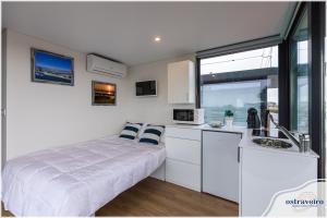 a small white kitchen with a bed and a sink at Barcos Casa OstrAveiro in Aveiro