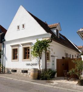 Una casa blanca con un árbol delante. en Casa.Peiso, en Mörbisch am See