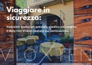 um sinal para um restaurante com mesas e cadeiras em Hotel Garni Le Corti em Grosotto