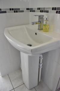 a white sink in a white bathroom at Witchingham B&B in Holyhead