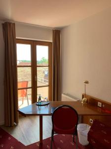 een kamer met een tafel en stoelen en een balkon bij Hotel Erlenbacher Hof in Bad Homburg vor der Höhe