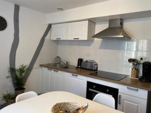 een keuken met witte kasten, een wastafel en een tafel bij Aventurine in Terrasson
